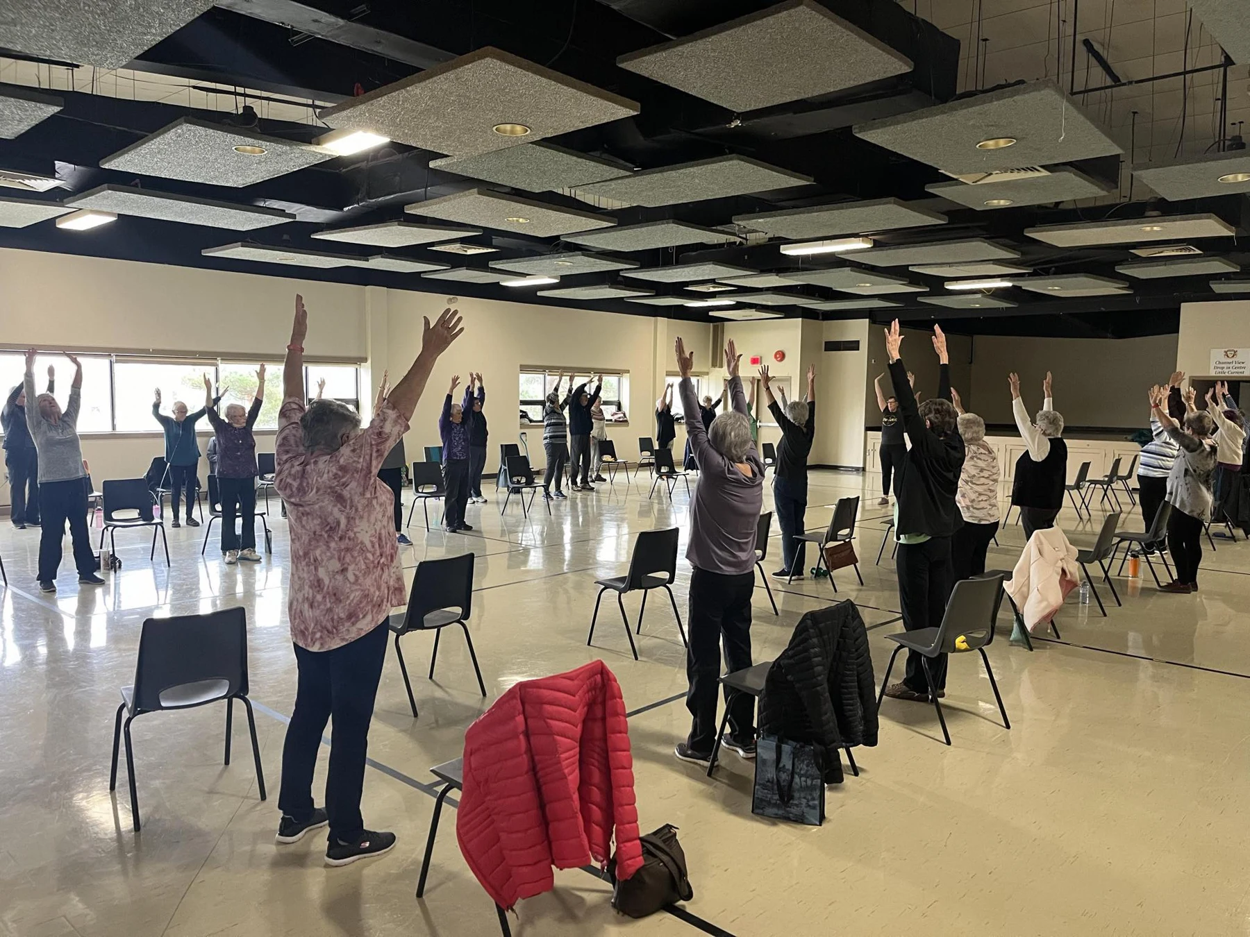 Group fitness participants stretching their arms overhead